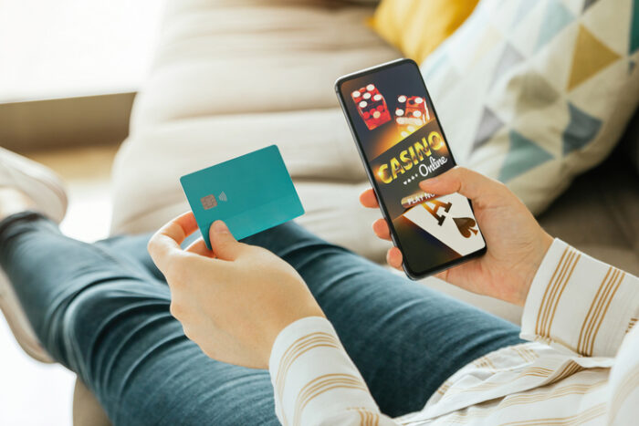 Stock photo of a woman going to play online casino and holding a credit card to pay. Online gambling and betting concept