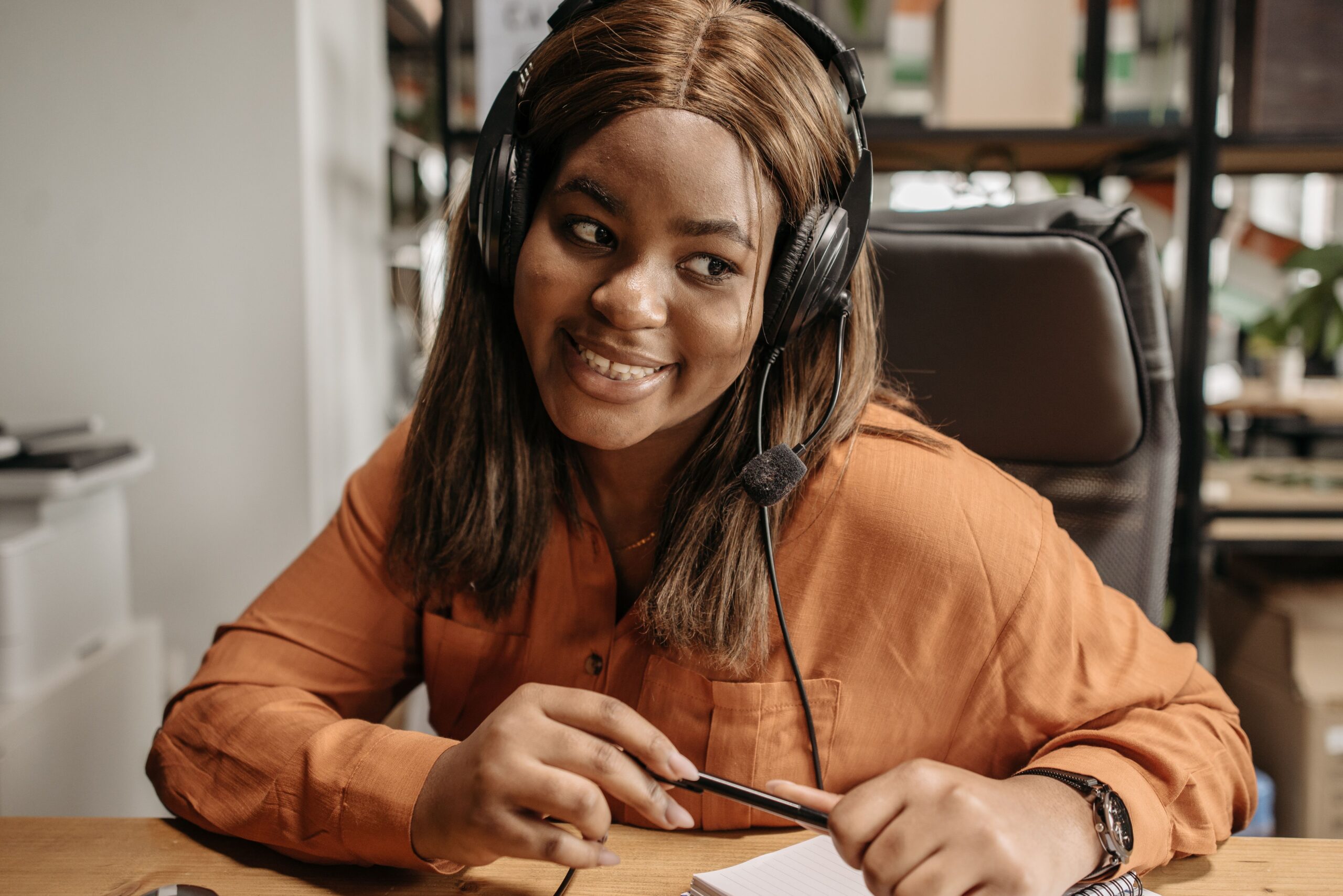 Cheerful customer support agent wearing a headset providing exceptional assistance in a modern office