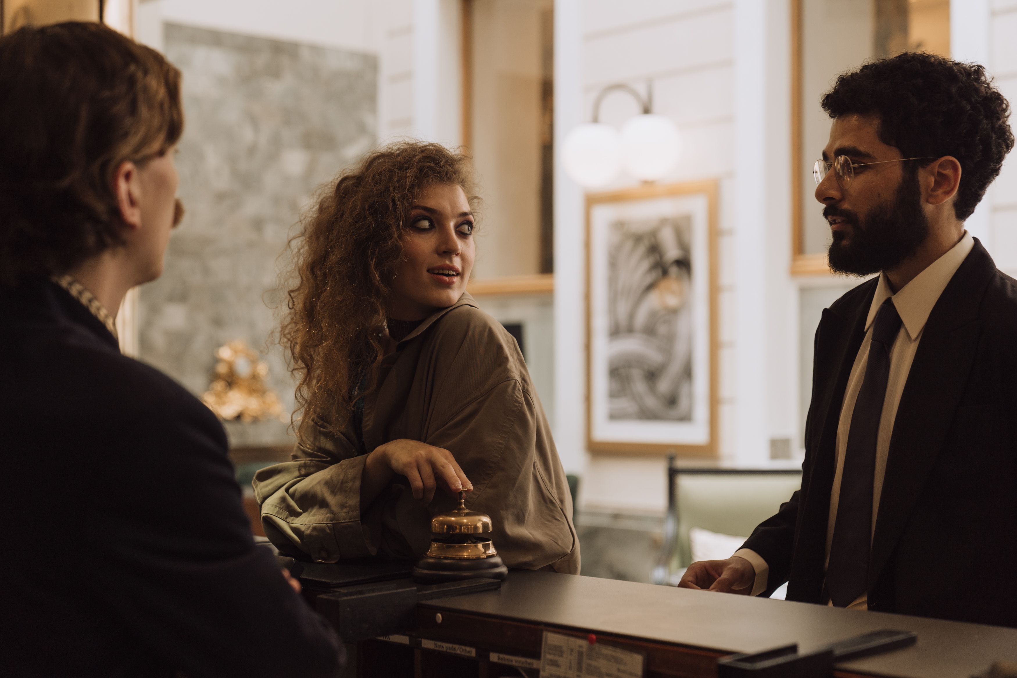Guests interacting at a luxurious hotel reception desk emphasizing hospitality and personalized service